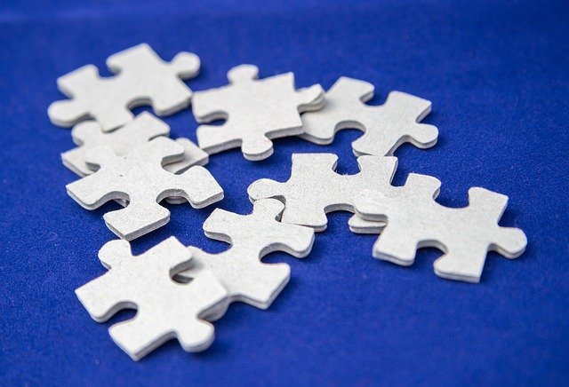 Piezas de puzzle blancas sobre fondo azul para indicar que el diseño lingüístico se construye