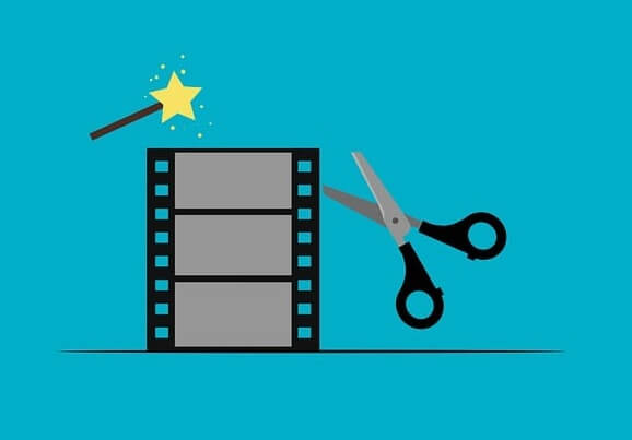 Tijeras al lado de celuloide y una varita mágica para representar el montaje cinematográfico