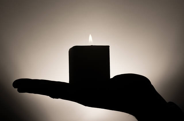 Vela encendida sobre una mano